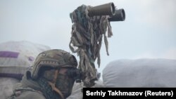 Un membru al forțelor militare ucrainene observă linia de demarcație din apropiere de Doneţk, oraș controlat de separatiștii sprijiniți de Moscova. 6 aprilie 2021