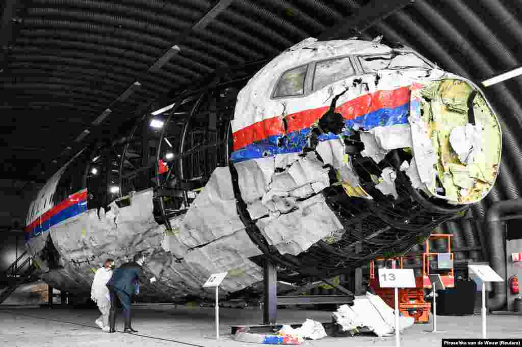 Юристи оглядають реконструйований корпус літака «Малайзійських авіаліній» рейсу МН17 на авіабазі Гільзе-Рієн у Нідерландах. 26 травня 2021 року