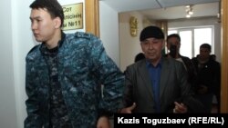 Конвой уводит подсудимого Болатхана Жунусова из зала судебного заседания после его выступления с последним словом. Талдыкорган, 21 октября 2019 года.