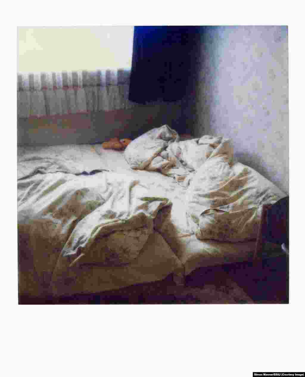 Polaroid fotografija kreveta u praznom stanu. Kada su obavljali tajne pretrese stanova, ovakve fotografije su koristile Štazi agentima u rukavicama da na vrijeme sve stvari vrate u prvobitni položaj, spremne za povratak vlasnika koji ne sumnja da je neko bio u stanu.