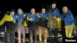 Unii dintre prizonierii ucraineni eliberați miercuri s-au înfășurat în steagul ucrainean. 