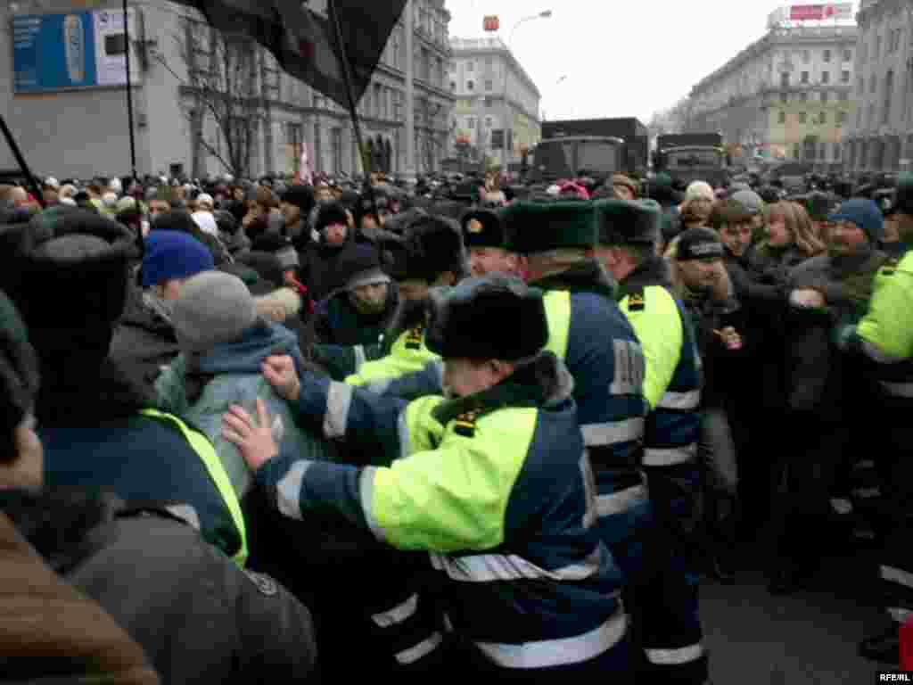 Міліцыянты выцясьняюць людзей з праезнай часткі.