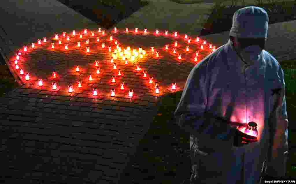 A Chernobyl power plant employee holds a candle near a memorial in the shape of a radioactivity sign in the Ukrainian city of Slavutych on April 25. Many of power station's personnel lived in Slavutych, located some 50 kilometers from Chernobyl.