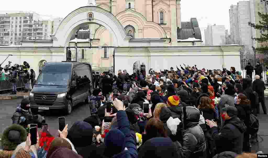 Людзі сустракаюць катафалк, які перавозіў труну зь целам расейскага апазыцыйнага палітыка Аляксея Навальнага перад адпяваньнем і разьвітальнай цырымоніяй у Маскве, Расея, 1 сакавіка 2024 году 
