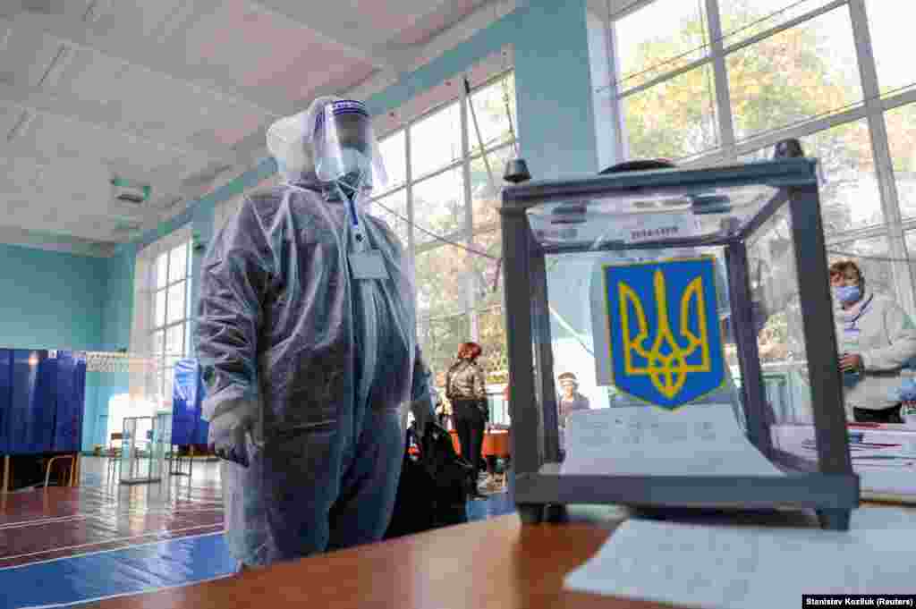Місцеві вибори у Слов&#39;янську. На фото:&nbsp;член виборчої комісії в засобах індивідуального захисту перевіряє урну на дільниці&nbsp;
