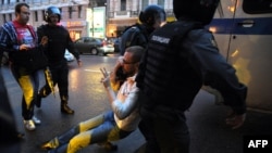 Полицейские задерживают сторонника оппозиции во время акции протеста в Москве. Согласно докладу Freedom House, Россия показала «драматический спад» по демократическим показателям.