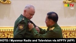 Бирманын хунта башчысы, улук генерал Мин Аунг Хлайн Орусиянын коргоо министринин орун басары Александр Фоминге медал тагууда. Найпидо шаары, Бирма. 2021-жылдын 26-марты.
