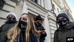 Susținătorii Memorial Internațional, purtând măști cu sigla organizației, așteaptă în fața Curții Supreme a Rusiei, după ce procurorii au solicitat dizolvarea organizației, cel mai important ONG de apărare a drepturilor omului din țară, Moscova, Rusia 28 decembrie 2021.