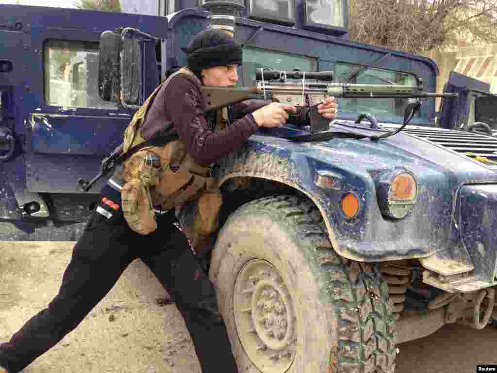 A member of the Iraqi security forces member aims his weapon during clashes with Al-Qaeda-linked jihadists in the city of Ramadi, the provincial capital of Anbar Province.