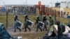 Беларускія сілавікі ў стыхійным лягеры мігрантаў на беларускім баку мяжы паблізу ад пераходу «Брузгі» — «Кузьніца» 18 лістапада 2021 году. Ілюстрацыйнае фота