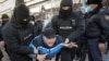 Сотрудники правоохранительных органов задерживают мужчину во время акции протеста против политических репрессий. в Алматы, 28 февраля 2021 года