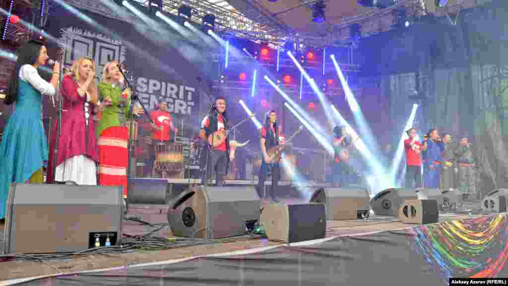 Момент открытия фестиваля The Spirit of Tengri. В глубине сцены – участники проекта «Барабаны Алматы». В центре – домбристы. Слева на сцене – девушки из литовской группы Marga Muzika. Справа – коллектив из Тувы Huun Huur Tu. Литовцы и тувинцы по программе выступают во второй день фестиваля.