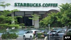 Indonesia -- Plainclothes police aim their handguns towards suspects outside a cafe after a series of blasts hit the Indonesia capital Jakarta, January 14, 2016