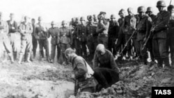 На цьому фото 1941 року радянські військовополонені копають собі могили під наглядом німецьких солдатів