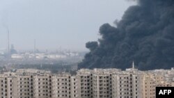 A thick plume of smoke rises above an oil refinery, situated to the west of the flashpoint city of Homs on December 8.