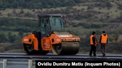 Muncitori care lucrează la construcția unei porțiuni de autostradă