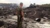 Боевик перед обломками «Боинга». 17 июля 2014 года