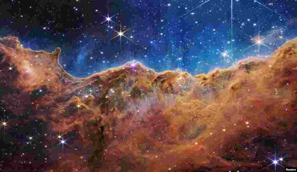 Stâncile cosmice ale Nebuloasei Carina se află la o distanță de 7.600 de ani lumină. Telescopul James Webb a avut capacitatea de a privi prin praful cosmic și de a captura în lumină infraroșie zone care nu au mai fost văzute până acum, în care se nasc stelele. 