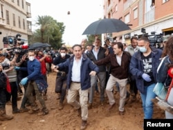 Locuitorii din Paiporta, lângă Valencia, aruncă cu noroi în Regele Felipe (Cel cu barbă, de sub umbrelă). Duminică, 3 noiembrie.