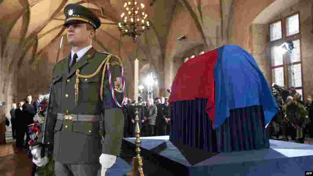 A soldier stands guard by the flag-draped coffin of the former Czech president, which is on display for people to pay their last respects ahead of a state funeral.