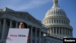 Вашингтондо Капитолийдин жанында TikTok тиркемесин колдор чыккае кыз. 