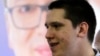 Danilo Vučić stoji ispred plakata na kome je njegov otac Aleksandar, fotoarhiv