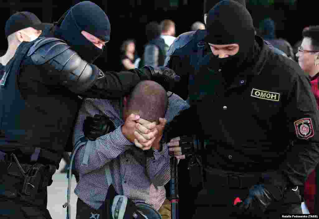 Un protestatar este scos din mulțime în Minsk.