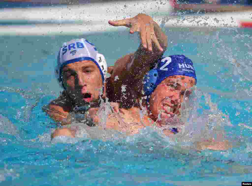 Gergo Zalanki of Hungary (right) and Nikola Jaksic of Serbia grapple with each other in an early round of the men's water polo competition. 