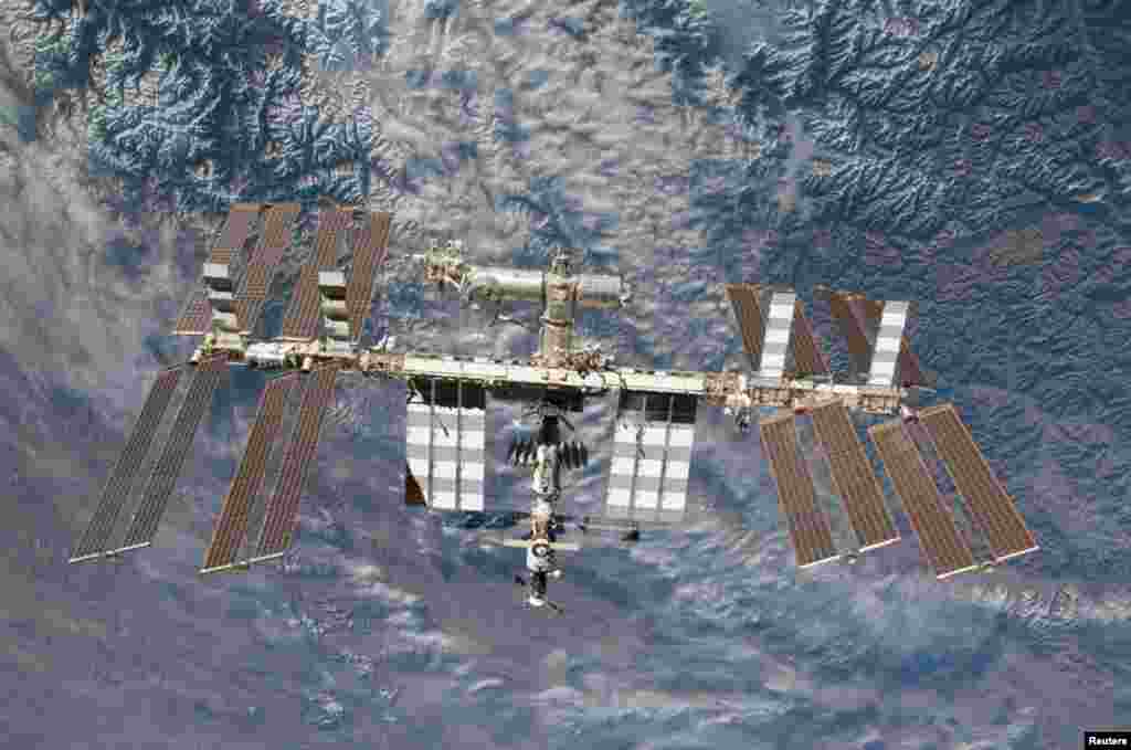 With Earth in the background, the International Space Station is seen in this image photographed by a crewmember on board the space shuttle Endeavour after the station and shuttle began their separation, in this undated NASA handout.