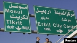 Workers add Turkoman language translations to traffic signs in multiethnic Kirkuk.