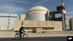 Radnik vozi bicikl ispred zgrade u kojoj se nalazi reaktor iranske nuklearne elektrane Bušer, 26. oktobar 2010.