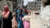 Palestinci pored srušenih kuća u Beit Hanounu u sjevernom pojasu Gaze, 21. maja 2021. 