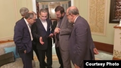 Iran's foreign minister, Abbas Araqchi (second left), and other members of the Iranian delegation confer at the talks in Muscat on April 12.