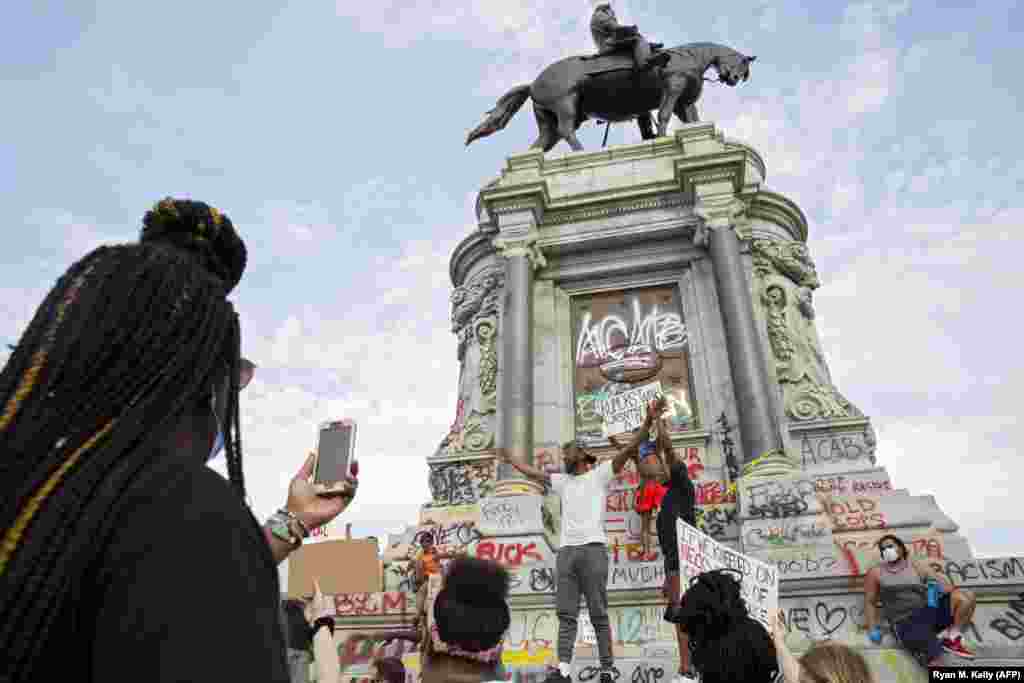 Oamenii se adună în jurul monumentului generalului Robert E. Lee, aflat la conducerea armatei sudiste în timpul războiului de secesiune, de pe Monument Avenue din Richmond, Virginia, la 4 iunie 2020, pe fondul continuării protestelor față de moartea lui George Floyd pe când se afla custodia poliției. La începutul zilei, guvernatorul de Virginia, Ralph Northam, a anunțat planurile de a îndepărta statuia generalului confederat, îndrumând Departamentul de Servicii Generale să o înlăture „cât mai curând posibil".