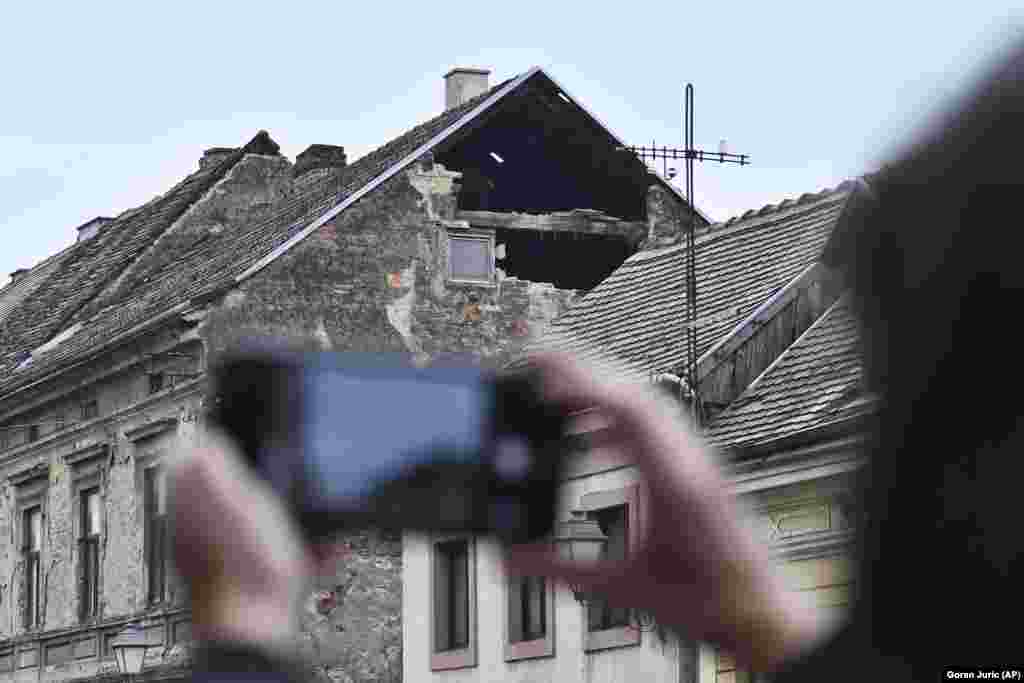 Stanovnik fotografira štetu uzrokovanu zemljotresom u Sisku u Hrvatskoj, u ponedjeljak, 28. decembra 2020. (AP Photo)
