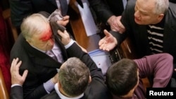 Ukrainian pro-government lawmaker Vladimir Malyshev is hurt during scuffles in parliament over an antiprotest law and other controversial legislation, which was passed on January 16.