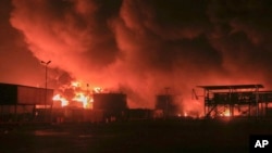 Oil tanks burn at the port in Hodeidah, Yemen, in July. (file photo)