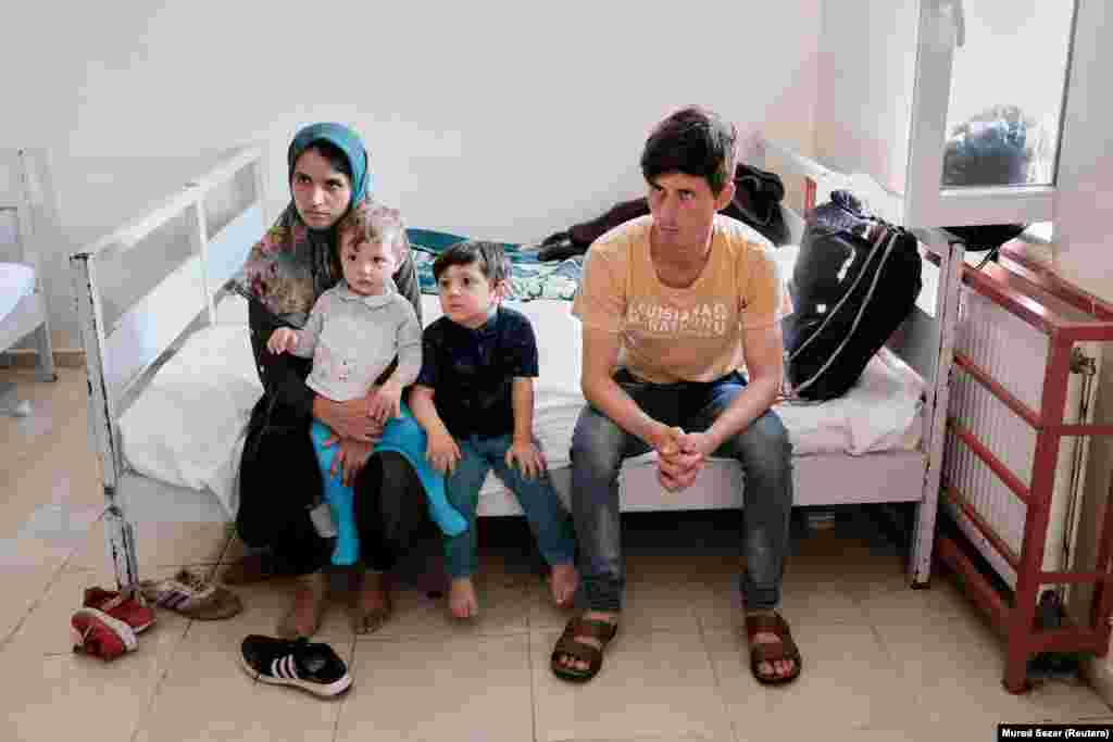 Afganistanski par Sajed Fahim Mousavi i Morsal Mousavi sa svojom djecom, koje su turske snage sigurnosti privele nakon što su ilegalno prešli u Tursku iz Irana, u centru za rad sa migrantima u pograničnom gradu Van, Turska (22. avgust)
