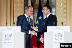 Президент Франції Емманюель Макрон і прем’єр-міністр Польщі Дональд Туск тиснуть руки під час зустрічі в Єлисейському палаці, Париж, Франція, 12 лютого 2024 року