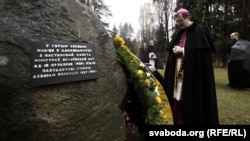 Пасол Ватыкану Кляўдыё Гуджэроці каля каменя з памятнай шыльдай, 2009 год. Надпіс на шыльдзе: «У гэтым лясным масіве ў адпаведнасці з пастановай Савета міністраў Беларускай ССР ад 18 студзеня 1989 года будзе пабудаваны помнік ахвярам рэпрэсій 1937–1941 гг.»