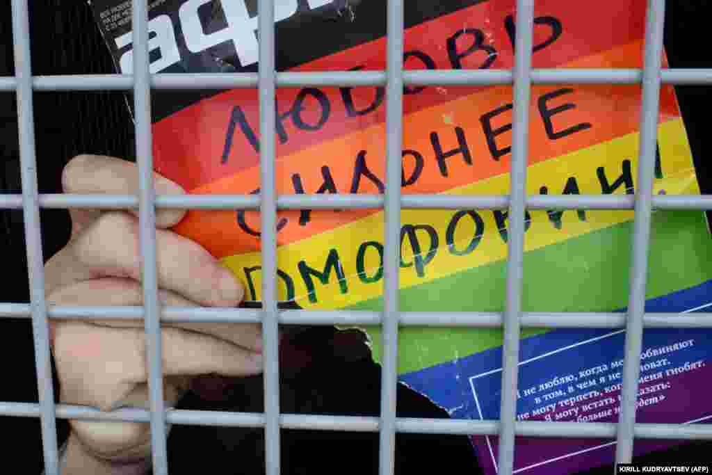 Un activist rus pentru drepturile LGBT ține un afiș pe care scrie „Iubirea este mai puternică decât homofobia!” după ce a fost arestat, în timpul unui miting neautorizat pentru drepturile homosexualilor din centrul Moscovei, în 25 mai 2013.