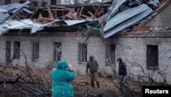 Locuitorii din Dnipro inspectează locul în care a atacat racheta Oreșnic (Alun) pe 21 noiembrie.