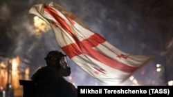 Мітингувальник тримає грузинський прапор під час протестів у Тбілісі 7 грудня 2024 року.