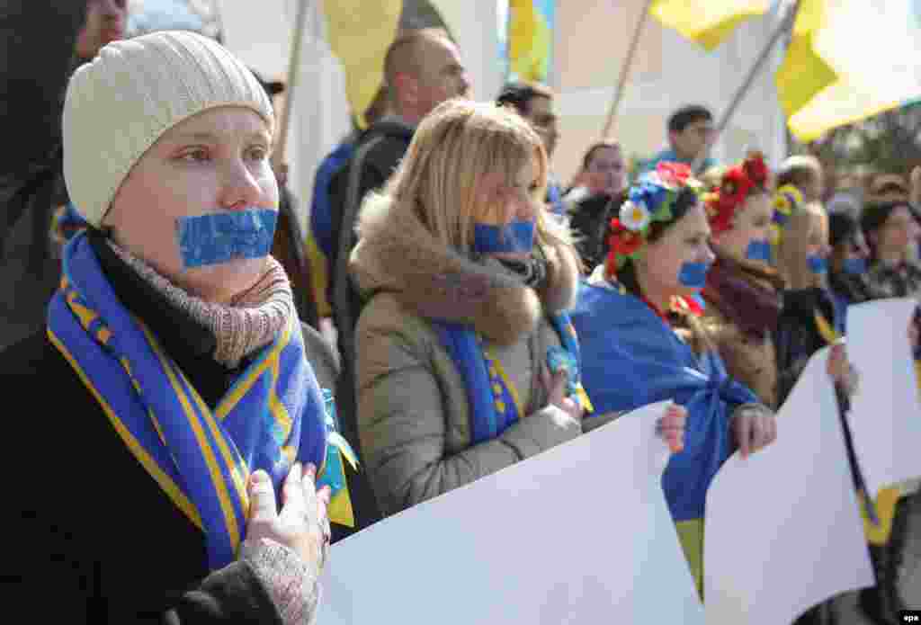 Учасниці акції, представниці руху «Жінки Криму за МИР», провели в Сімферополі мовчазну акцію на підтримку свободи слова. Дівчата заклеїли собі роти синьою стрічкою, а в руках тримали чисті плакати без єдиної літери. 13 березня 2015 року