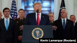 U.S. President Donald Trump delivers a statement about Iran flanked by U.S. Secretary of Defense Mark Esper (far left), Vice President Mike Pence (far right) and military leaders in the Grand Foyer at the White House in Washington on January 8.