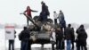 Armament rusesc greu se află deja în estul Ucrainei. E folosit de separatiștii sprijiniți de Moscova. În conflictul armat început în 2014 au murit deja peste 13.000 de oameni. În imagine: locuitori din Luhansk se fotografiază alături de un tanc T-72 al separatiștilor, în 2020.