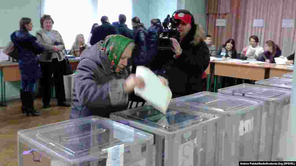 Добуш берүү Украинанын чыгышындагы москвачыл жикчилдердин ээлигиндеги 14 райондо болбойт. Борбордук шайлоо комиссиясынын маалыматы боюнча, шайлоого алты миңден ашык талапкер катталган. Шайлоога 29 партия ат салышууда, ага 600дөй эл аралык байкоочулар көз салып жатат. Сүрөттө: Киевдеги шайлоо бекетине добуш бергени келген шайлоочулар. 26-октябрь, 2014-жыл. 
