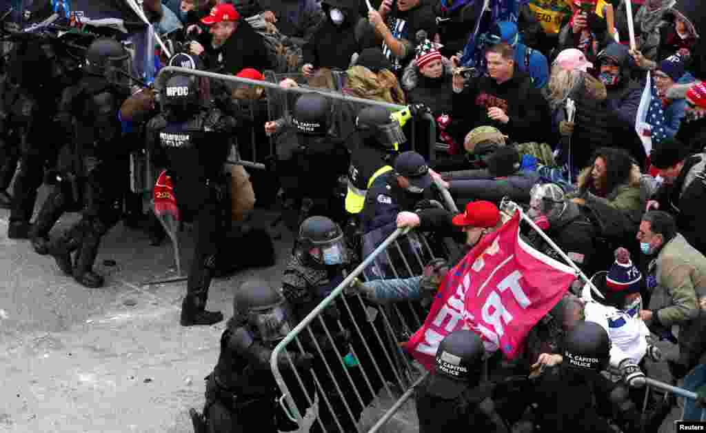 Pristalice predsjednika SAD Donalda Trampa pokušavaju srušiti policijsku barikadu tokom skupa kojim se osporava potvrđivanje rezultata američkih predsjedničkih izbora 2020. od strane Kongresa SAD-a, ispred zgrade američkog Kapitola u Washingtonu, SAD, 6. januara 2021. godine.