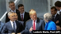 NATO Secretary General Jens Stoltenberg (left), US President Donald Trump (center) and Britain's Prime Minister Theresa May talk at the NATO summit in Brussels on July 11.
