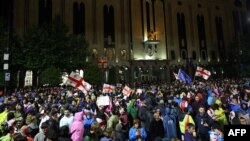 Protestatari flutură steagurile Georgiei și UE în timpul protestului împotriva proiectului de lege privind „influența străină”. Tbilisi, 12 mai 2024.